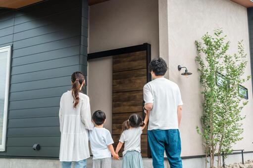 住宅の前で暮らす家族の後ろ姿